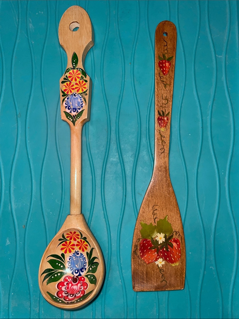 Two handpainted wooden kitchen utensils